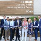 Group ribbon-cutting at UC Davis Veterinary Medical Center, blue and yellow balloon columns